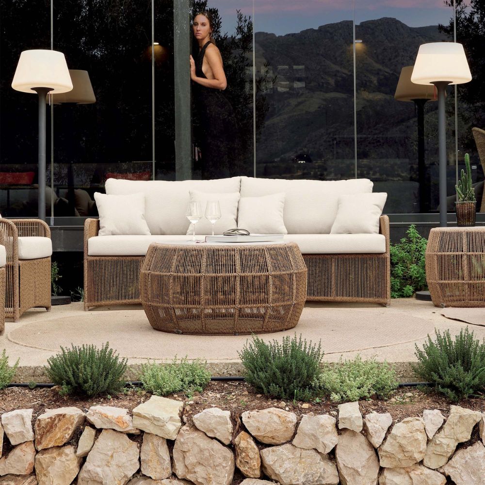 Outdoor patio with wicker furniture, white cushions, and a mountain view.