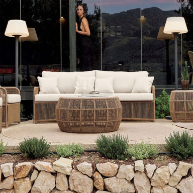 Outdoor patio with wicker furniture, white cushions, and a mountain view.