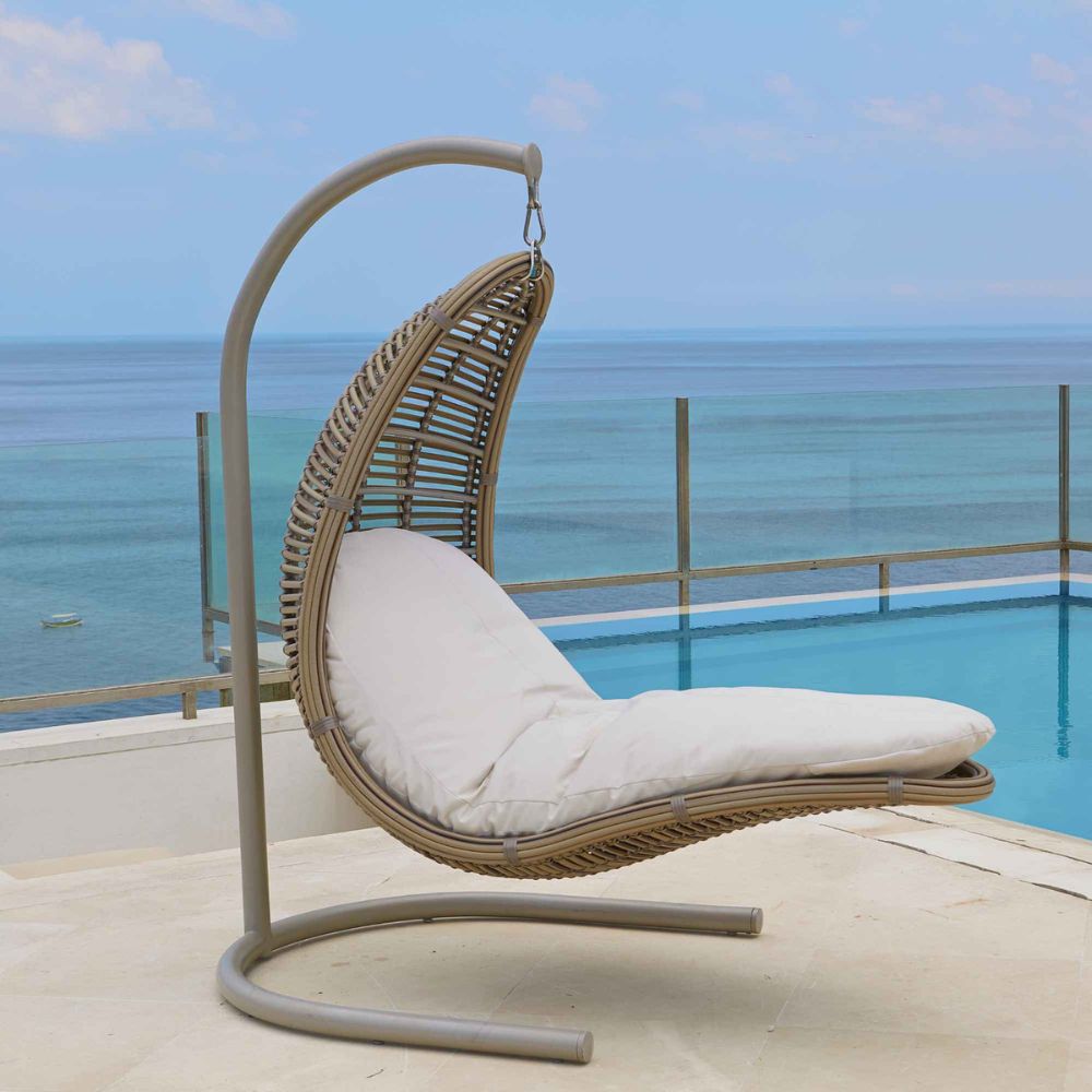Hanging chair with white cushion on a balcony with ocean view