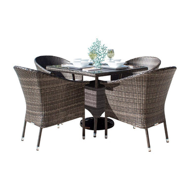 Outdoor dining set with four wicker chairs and a round table on a white background