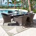 Outdoor dining set with table and chairs on a patio by a pool with palm trees and ocean view.