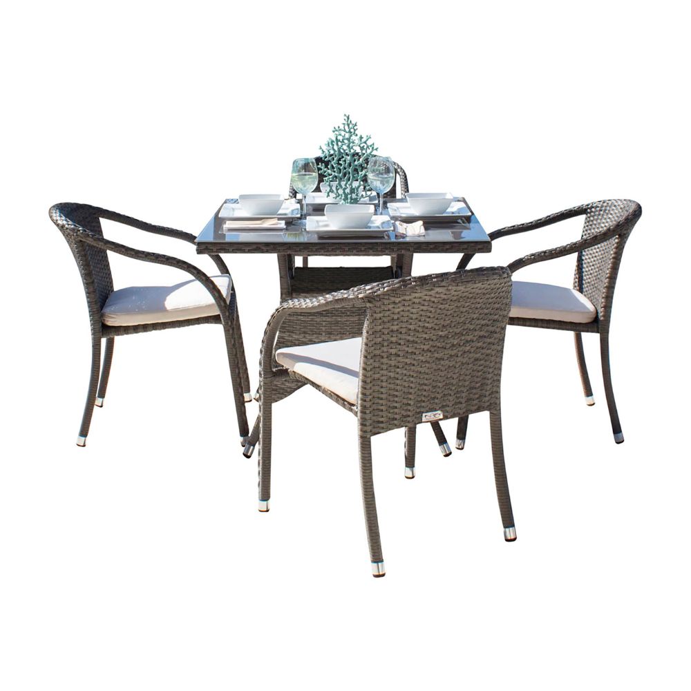 Outdoor dining set with four chairs and a glass table on a white background