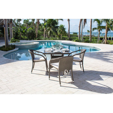 Outdoor dining set by a pool with palm trees in the background