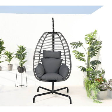 Hanging egg chair with gray cushions in a room with plants