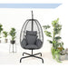 Hanging egg chair with gray cushions in a room with plants