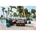 Outdoor patio furniture set with palm trees and pool in the background