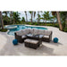Outdoor patio furniture set with a pool and palm trees in the background