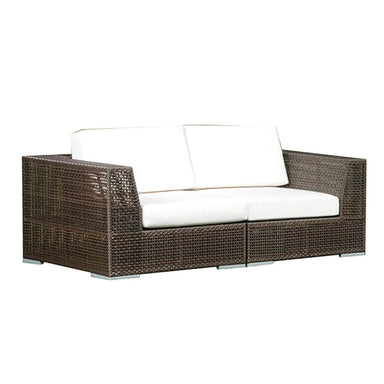 Brown wicker outdoor sofa with white cushions on a white background