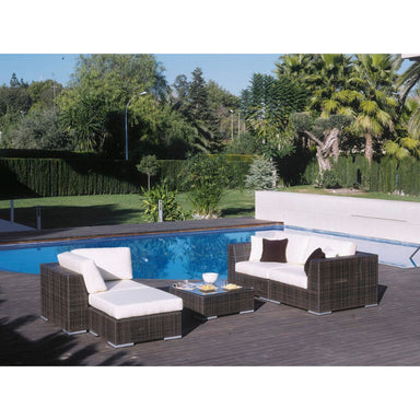 Outdoor patio furniture set with white cushions by a pool