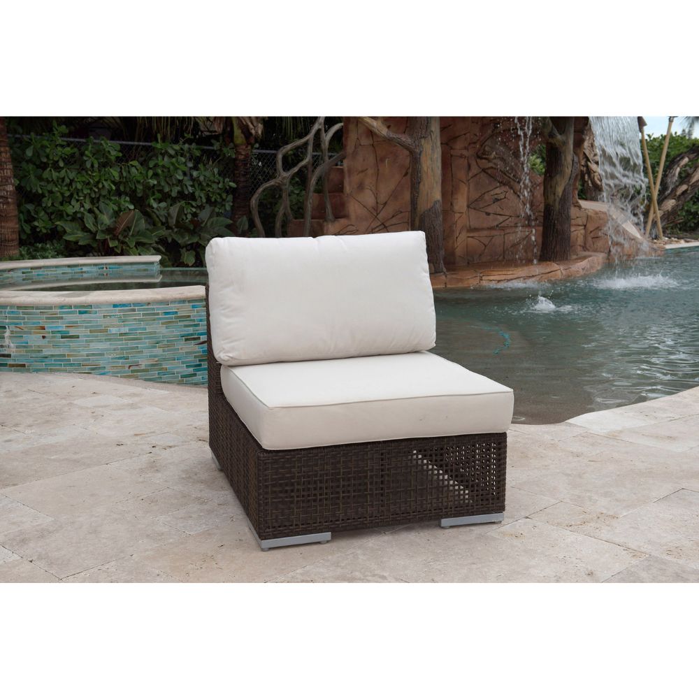 Outdoor wicker chair with white cushions by a pool