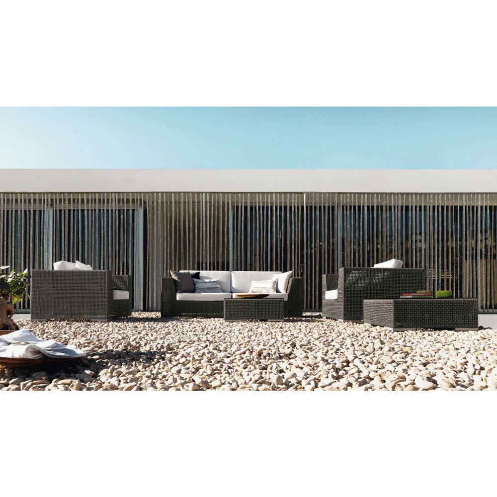 Outdoor patio furniture set on a pebble-covered ground with a clear blue sky.