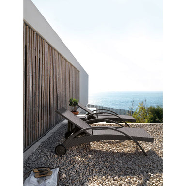 Two lounge chairs on a pebble patio with ocean view