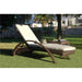Wicker outdoor lounge chair with white cushion on grass