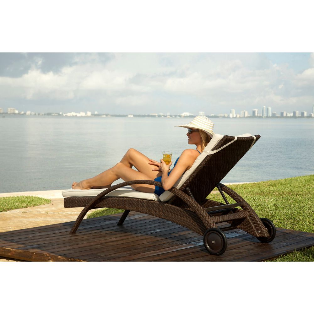 Woman relaxing on a sun lounger by the water