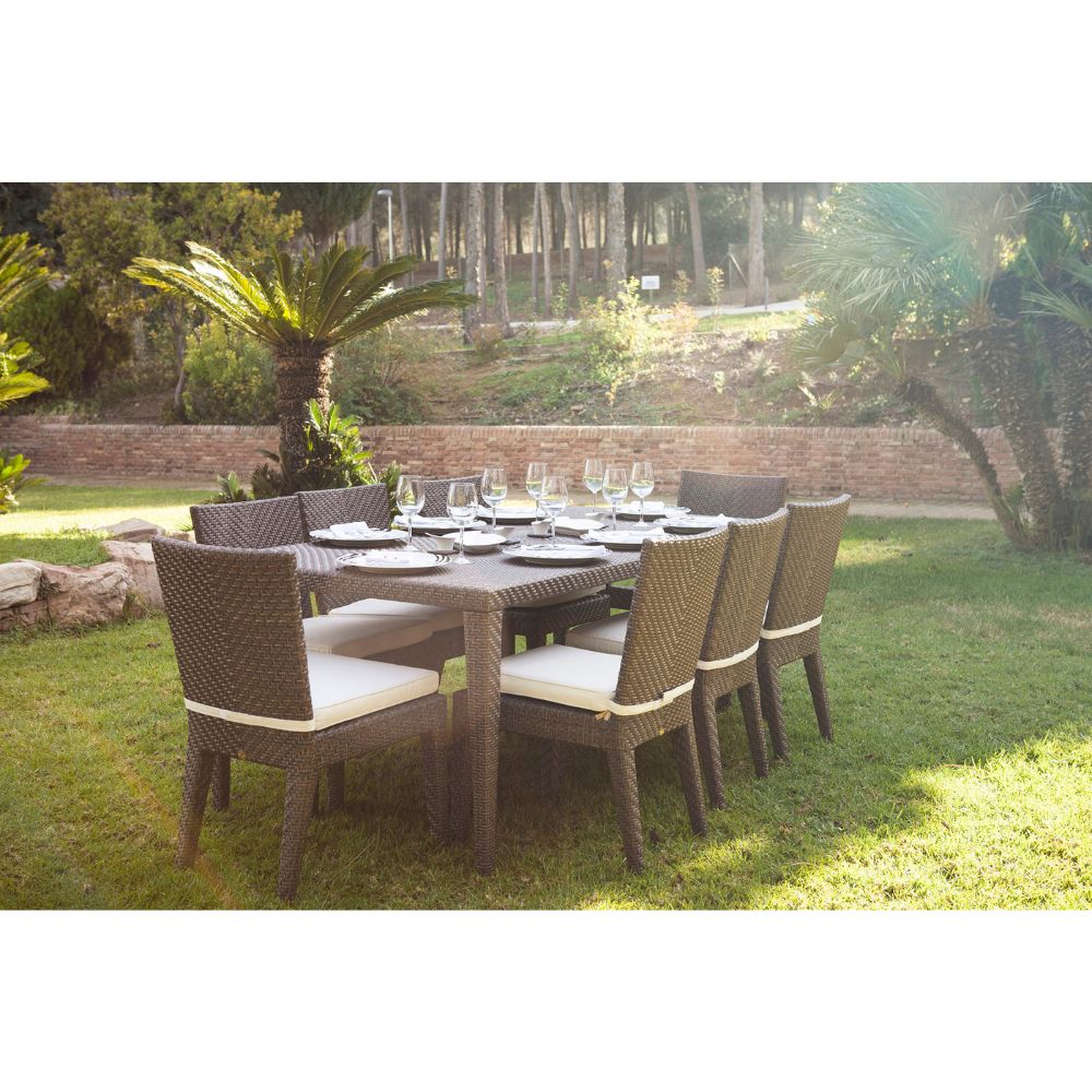 Outdoor dining set with table and chairs on a grassy area with trees in the background