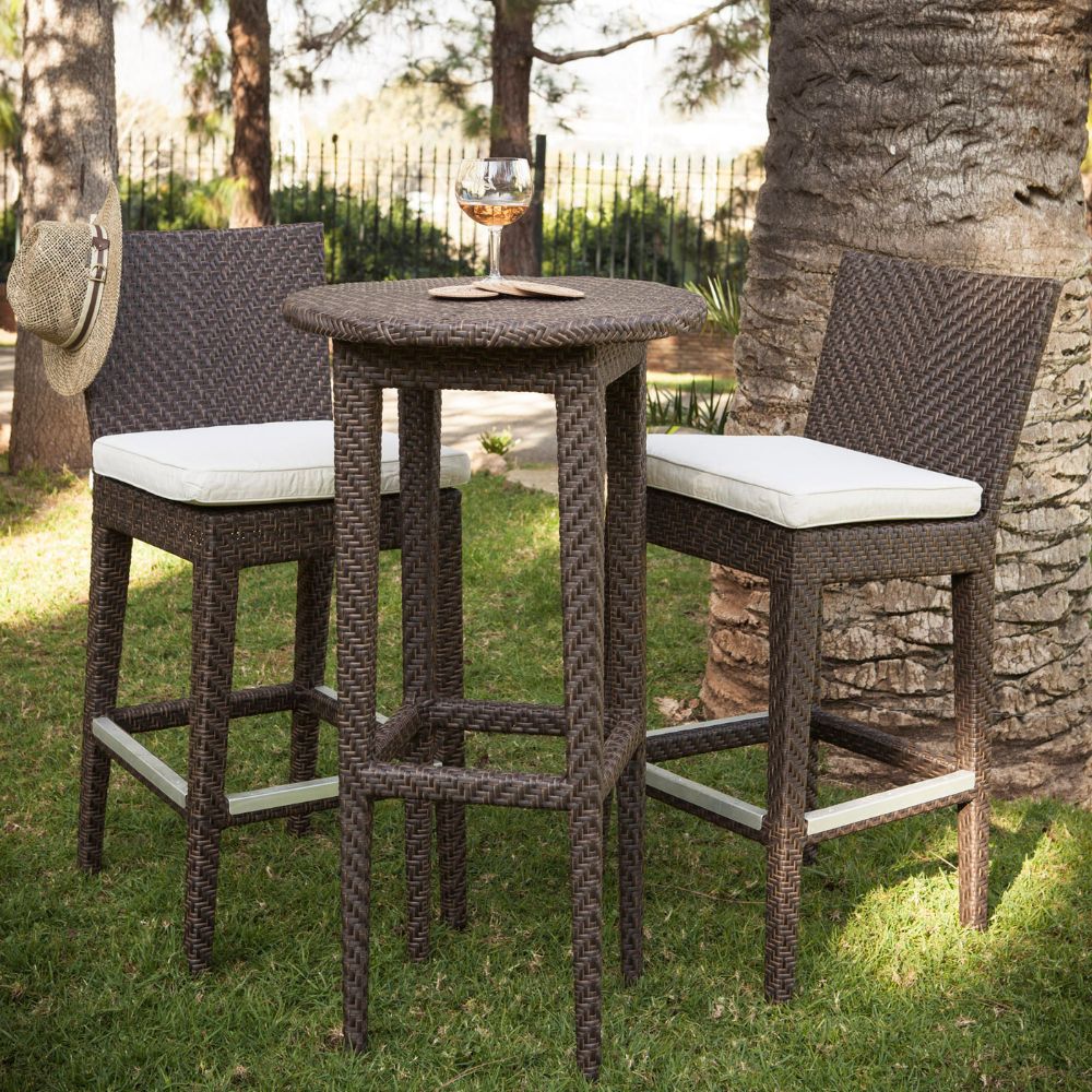 Outdoor patio set with two bar stools and a small table on grass.