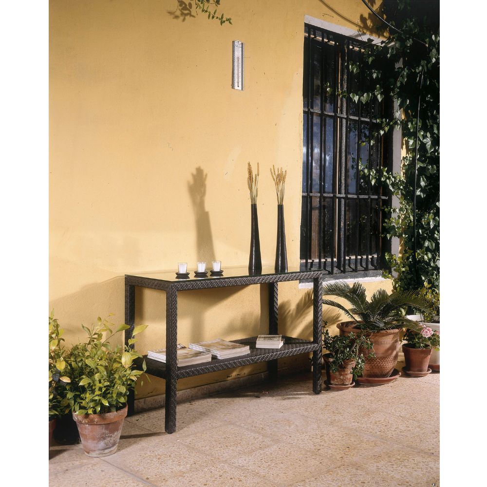 Wrought iron console table with decorative items against a yellow wall