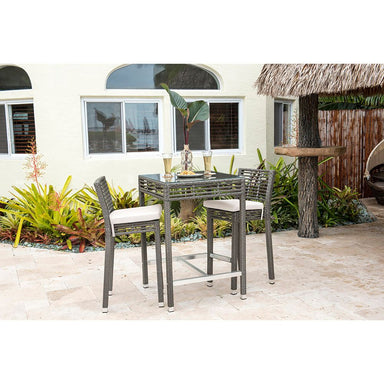 Outdoor patio set with a glass table and chairs on a patio area.