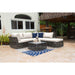 Outdoor patio set with a sectional sofa and coffee table on a stone patio.