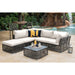 Outdoor patio furniture set with a sofa, ottoman, and coffee table in a garden setting.