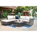 Outdoor patio furniture set with cushions on a patio with a pool and tropical plants in the background.