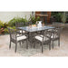 Outdoor patio set with table and chairs on a patio with plants in the background