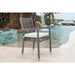 Outdoor chair with white cushion in front of a pool and waterfall