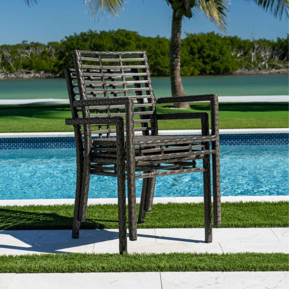 Two wooden chairs by a pool with a scenic background