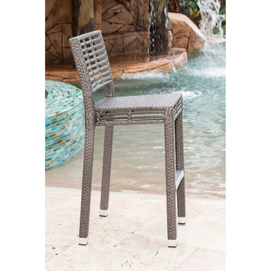 Wicker chair by a pool with water features in the background