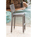 Wicker chair by a pool with water features in the background