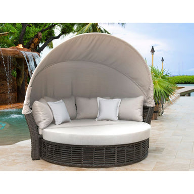 Round outdoor lounge chair with canopy in a poolside setting