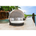 Round outdoor lounge chair with canopy in a poolside setting