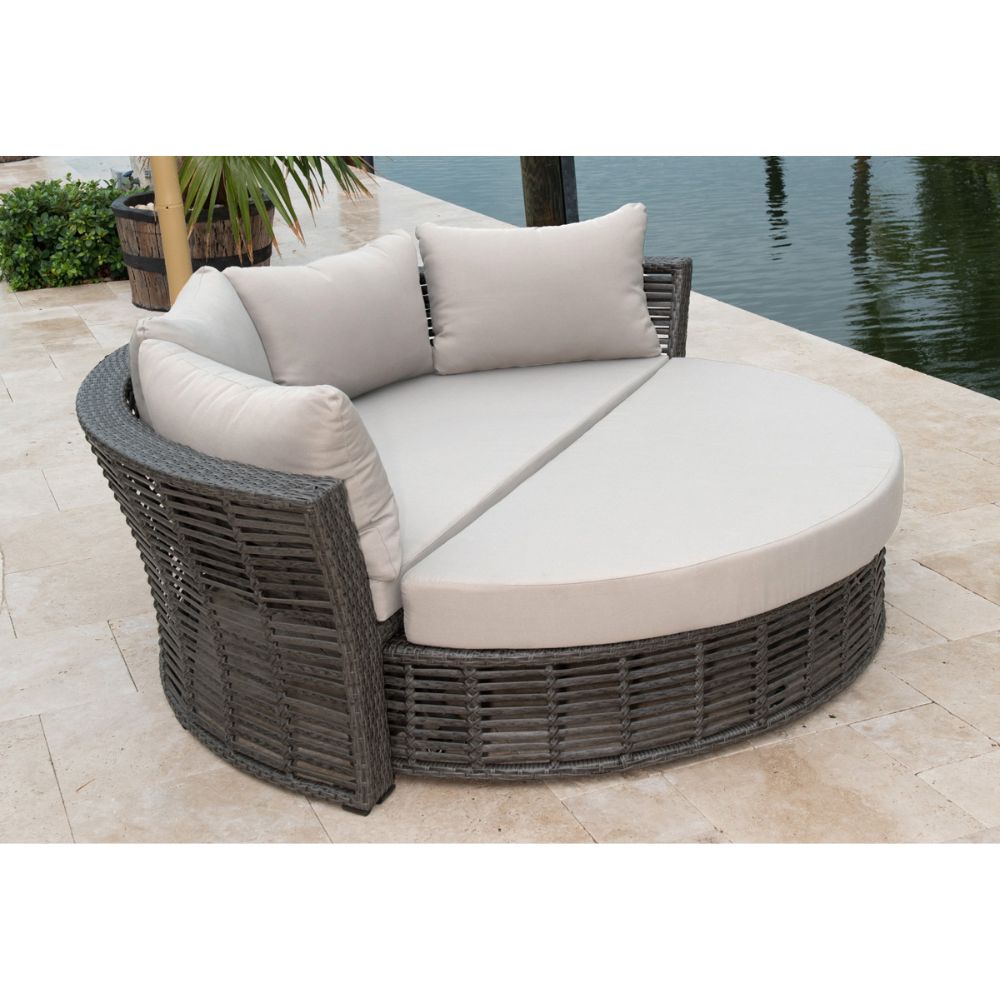 Round outdoor patio sofa with cushions by a water body