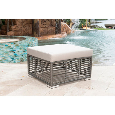 Outdoor ottoman with white cushion near a pool
