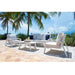 Outdoor patio set with chairs and table on a stone patio with palm trees and ocean view.
