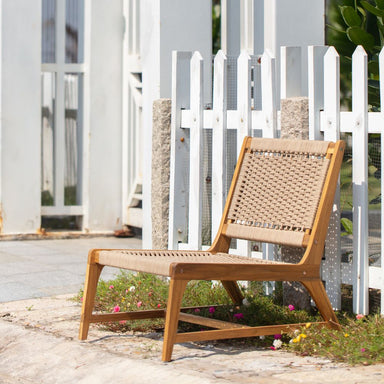 Wooden outdoor chair with woven backrest in a garden setting