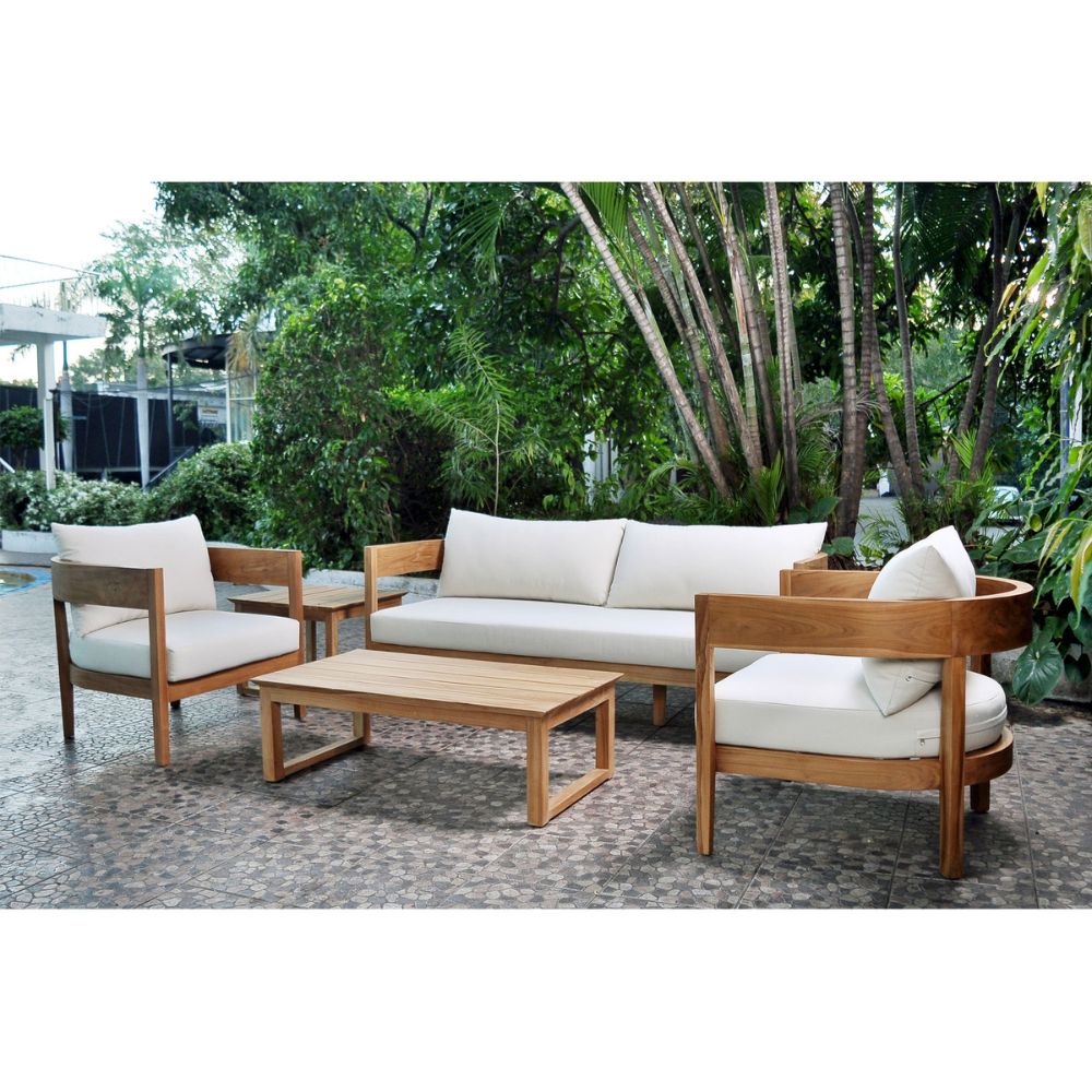 Outdoor furniture set with wooden frames and white cushions in a garden setting.