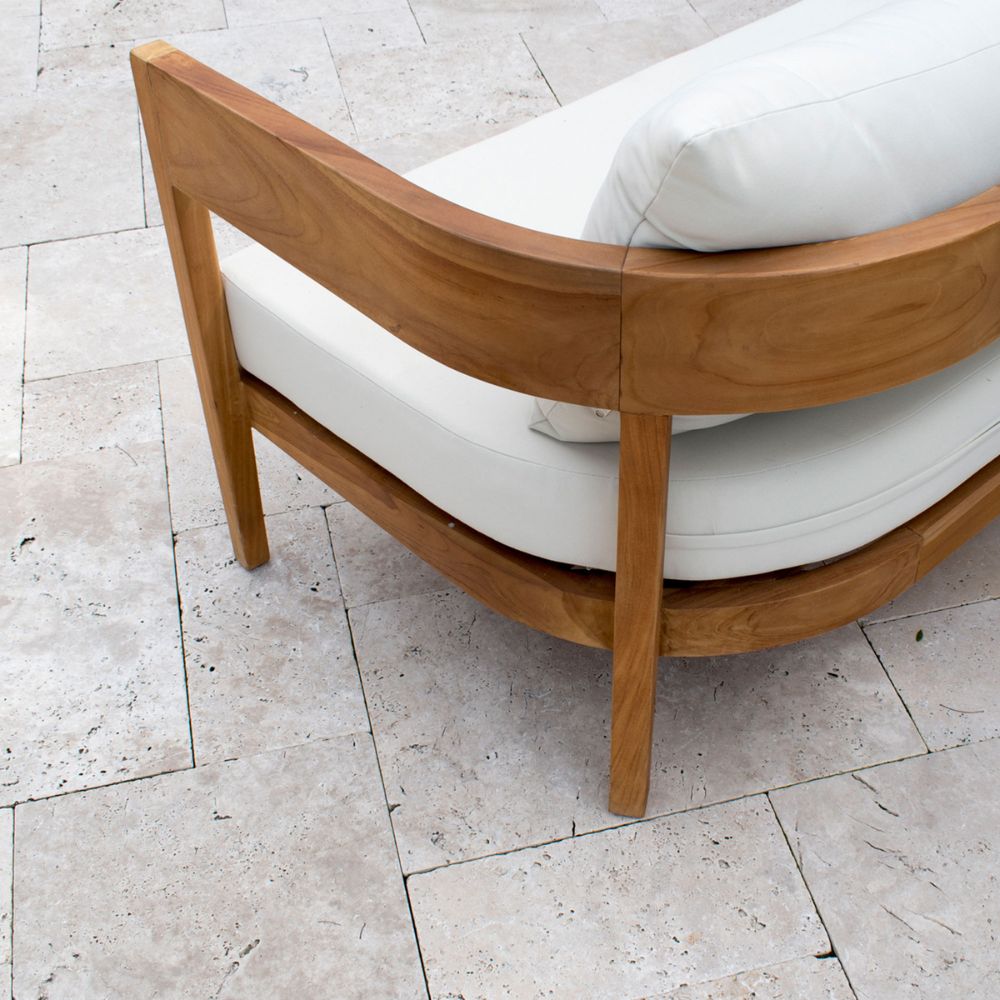 Wooden chair with white cushion on a tiled floor