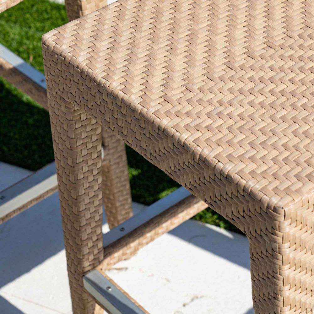 Close-up of a woven wicker chair with a blurred outdoor background