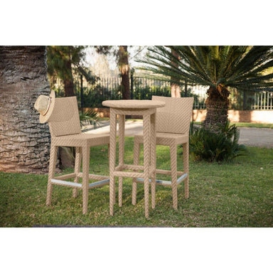 Beige outdoor bar set with two stools and a table on grass with palm trees in the background