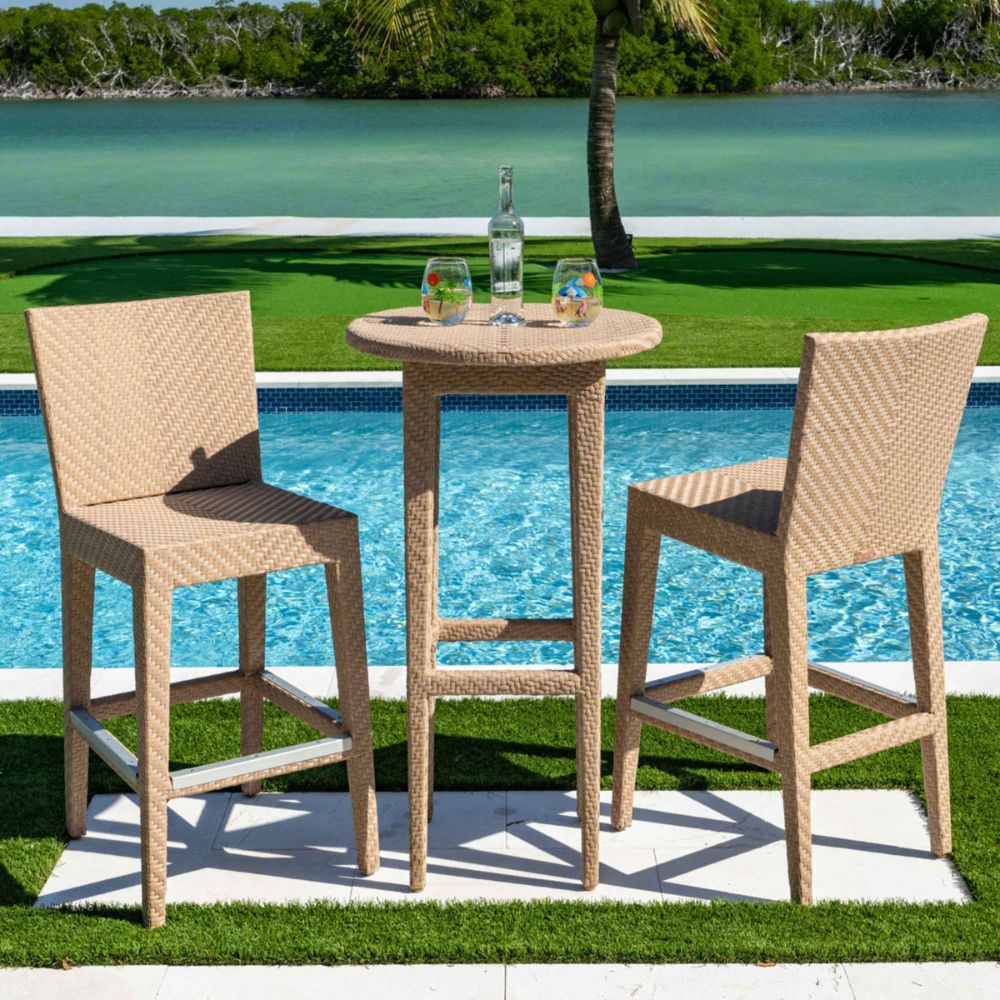 Outdoor patio set with two bar stools and a small table by a pool
