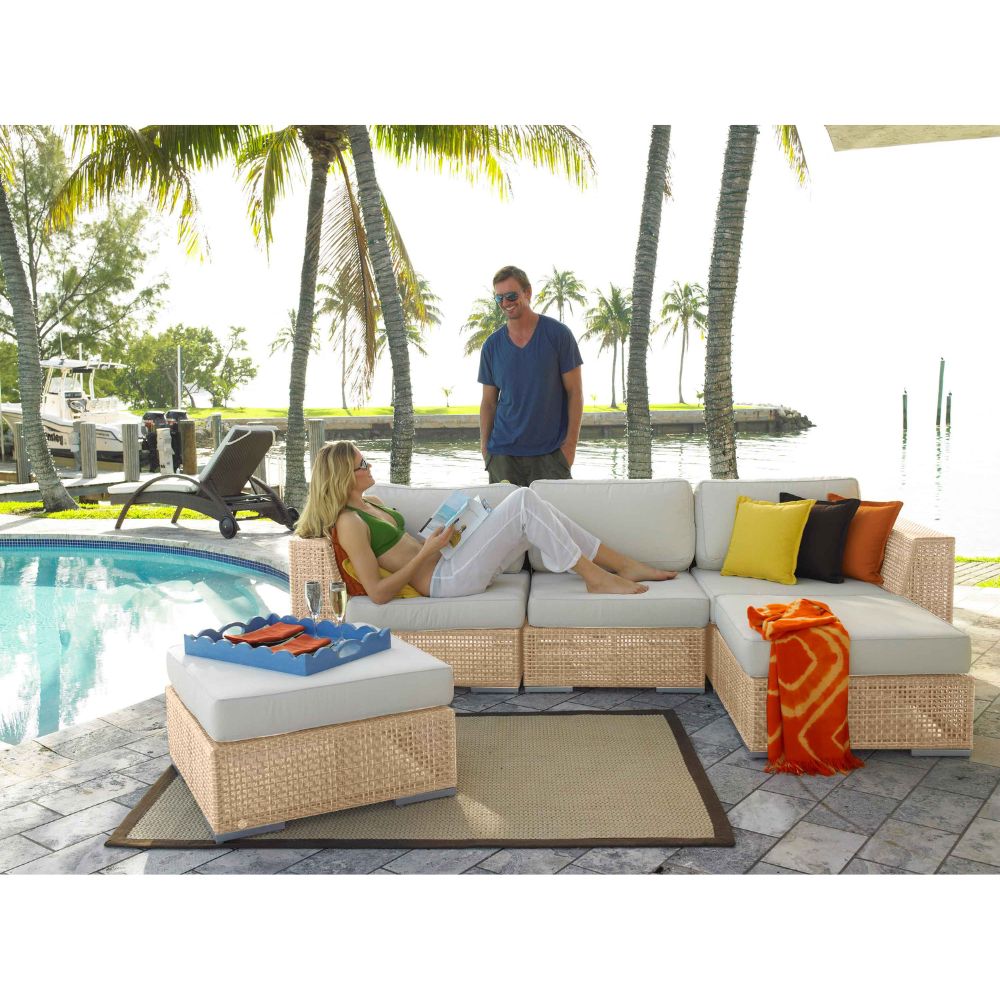 People relaxing on a patio with outdoor furniture by a poolside.