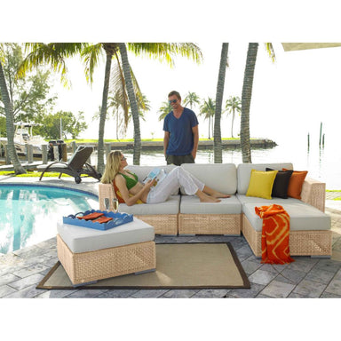 People relaxing on a patio with outdoor furniture by a poolside.