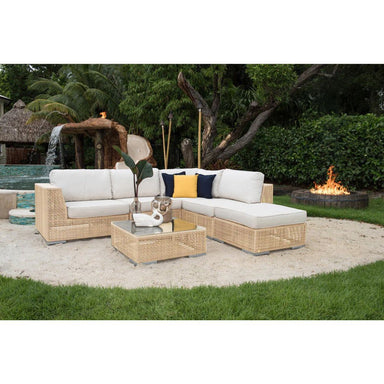 Outdoor patio furniture set with a fire pit and fountain in the background