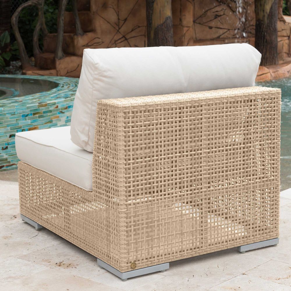 Wicker outdoor chair with white cushions by a pool