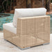 Wicker outdoor chair with white cushions by a pool