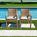 Two wicker chairs with cushions by a poolside on a sunny day.