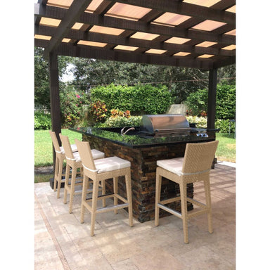 Outdoor kitchen bar with grill under a pergola in a garden setting