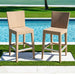 Two wicker bar stools by a poolside on a sunny day.
