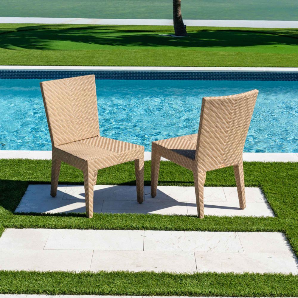 Two wicker chairs by a poolside on a sunny day